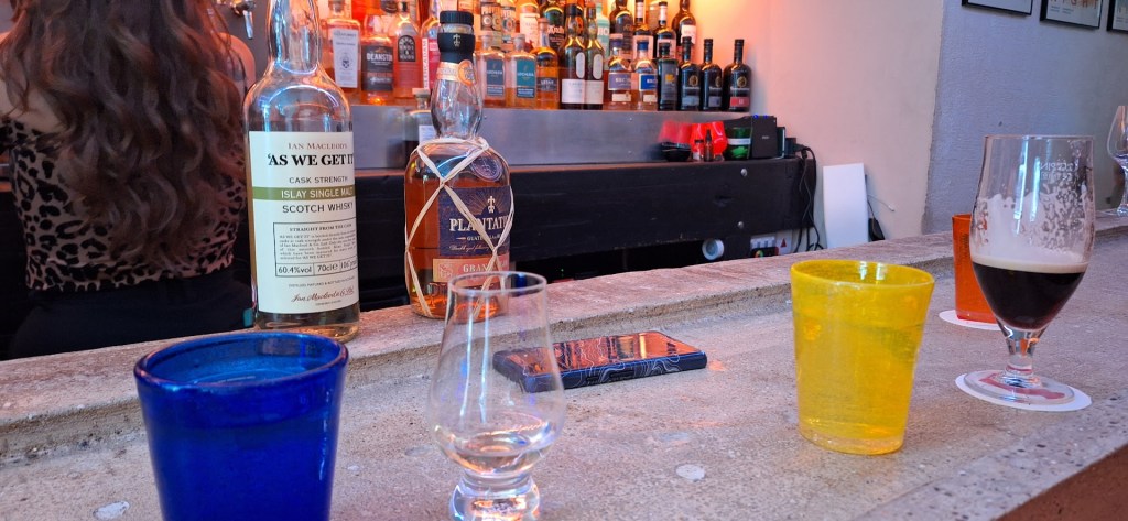 Dram Bar in action with cups, bottles and more present on the stone bartop