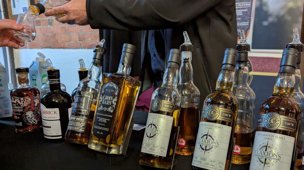 A range of Claxton's bottles at Exploring Whisky Bristol with one being poured to an attendee